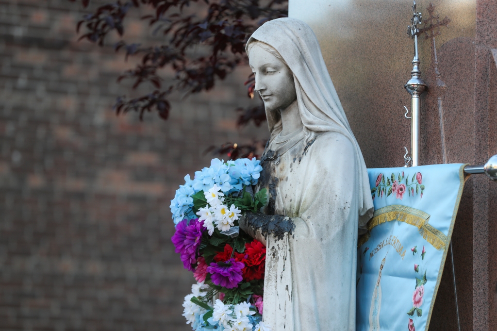 The Virgin Mary statue is pictured during a vigil at St. Peter's Parish-Dorchester after it was burned in Dorchester, Boston. 