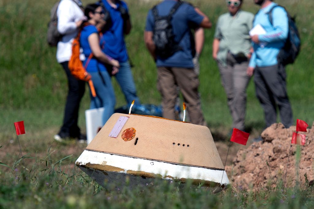 A model of the OSIRIS-REx (Origins, Spectral Interpretation, Resource Identification, and Security  Regolith Explorer) lies in a field during a sample capsule recovery rehearsal on June 27, 2023,